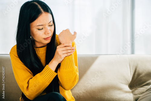 A woman experiencing wrist pain or Carpal Tunnel Syndrome holds her achy joint. Depicting discomfort inflammation and symptoms in the hand's anatomy. Health care concept