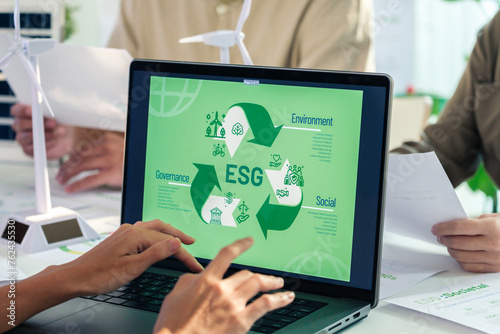 ESG ( environment, social,governance) recycle sign on laptop screen with carbon free chart board in office