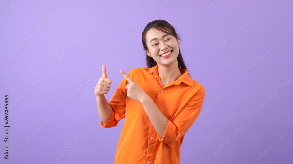 The Asian woman pointed to the side with an expression of surprise and joy
