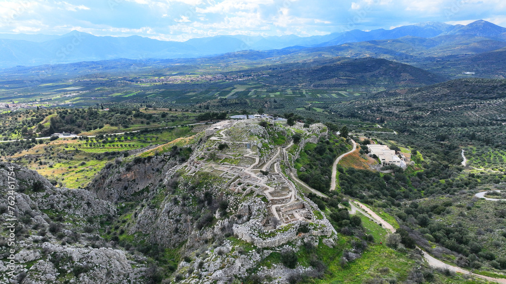 Aerial drone scenic photo of uphill iconic archaeological site of Ancient citadel of Mycenae famous for round tomb of Agamemnon and Lion Gate, Argolida, Peloponnese, Greece Aerial drone scenic photo of uphill iconic archaeological site of Ancient citadel of Mycenae famous for round tomb of Agamemnon and Lion Gate, Argolida, Peloponnese, Greece