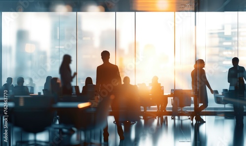 Busy business people in an office building glass facade, walking fast in the office at sunset reflection