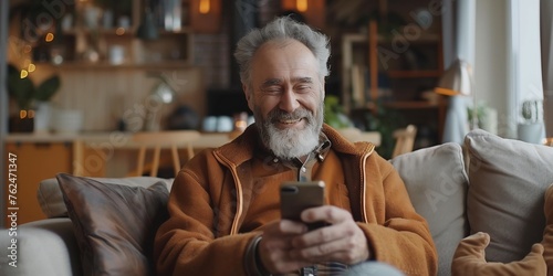 Bearded old man surfs the internet on his phone. Concept of browsing the internet on the phone, spending time.