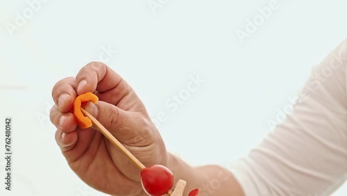 The chef dresses fresh vegetables for the grill on a stick