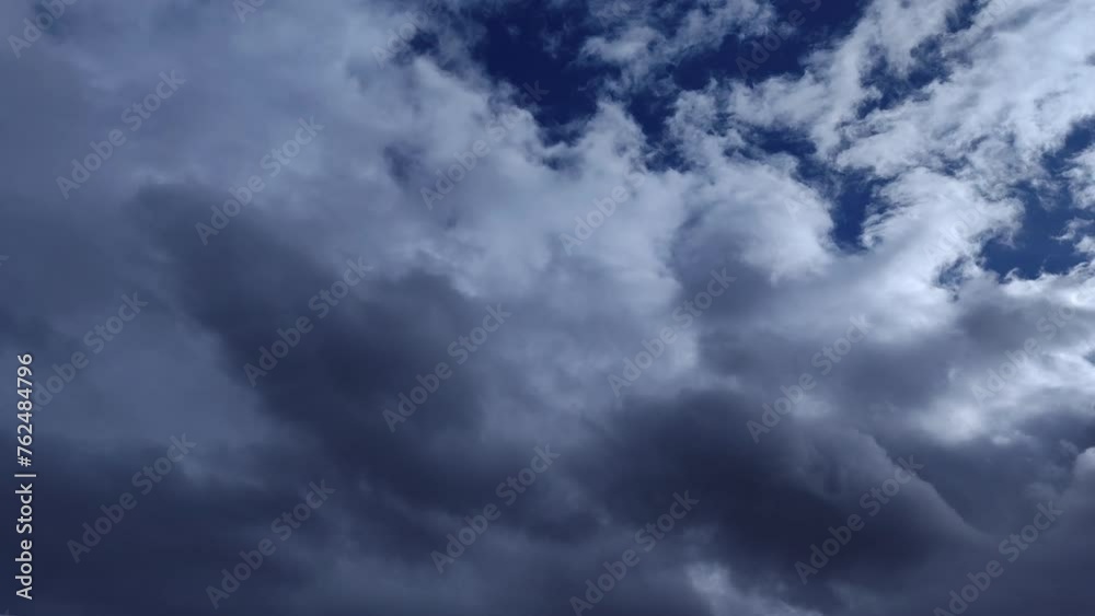 Altocumulus and cirrocumulus clouds of dark tones circulate across the bright sky Altocumulus and cirrocumulus clouds of dark tones circulate across the bright sky