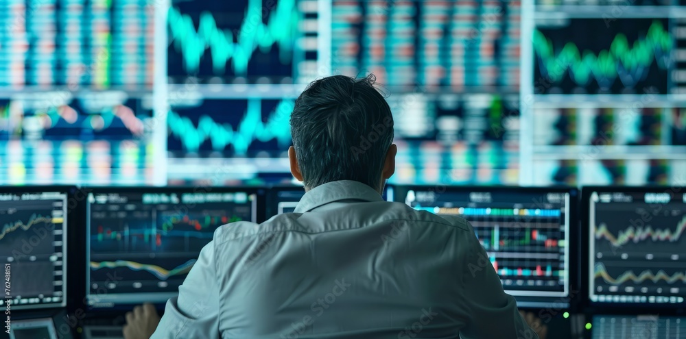 Stock Trader Monitoring Market Data - Multiple Computer Screens Setup
