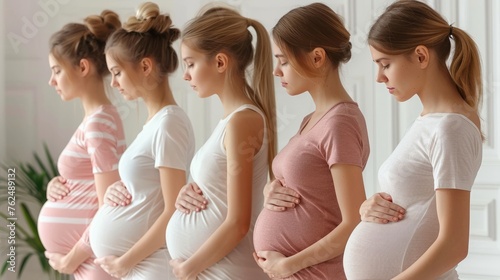 A group of five diverse pregnant women standing together, smiling and holding their baby bumps in late stages of pregnancy, expressing joy and anticipation.