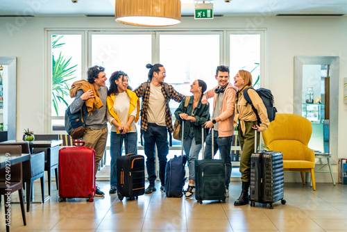 Young group of tourists with suitcases arriving at youth hostel guest house - Happy friends enjoying summer vacation together - Millenial people doing check-in at hotel lobby - Summertime holidays photo