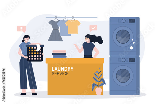 Staff at reception counter, female staff at dry-cleaning and laundry. Washing machines and various clean clothes. Woman client give dirty clothes for laundry service.