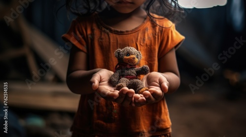 Hands of a child holding a toy in a temporary shelter photo