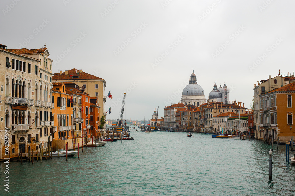 Stunning view of the Venice skyline with the Grand Canal and Basilica Santa Maria Della Salute in the distance  from Ponte Dell’ Accademia in a cloudy weather. Veneto, Italy