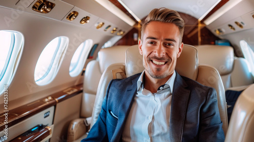 A smiling rich young businessman is flying in a luxury private jet. photo