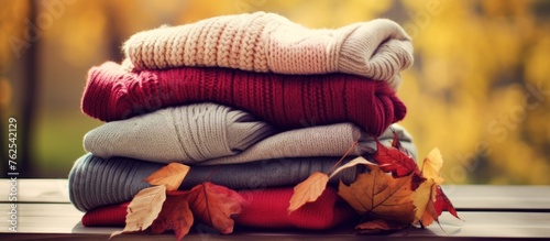 Pile of knitted woolen sweaters autumn colors.