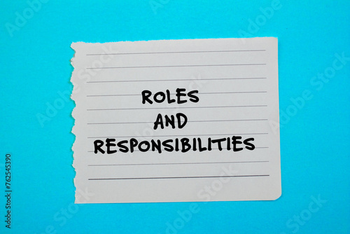 Roles and responsibilities words written on torn paper piece with blue background. Conceptual symbol. Copy space.