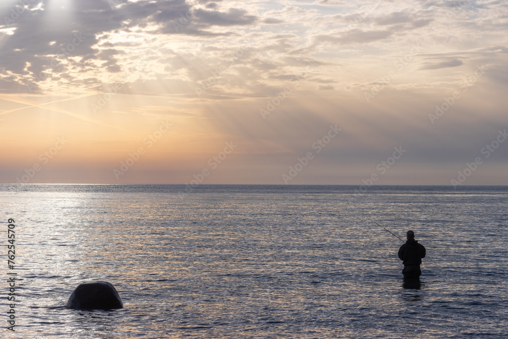 Fototapeta premium Meerforellen Angler im flachen Wasser an der Ostseeküste.