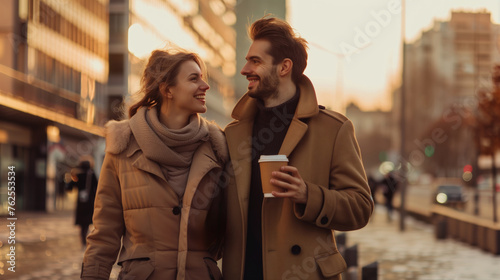 A man and a woman walking down the street smiling and drinking coffee  golden hour