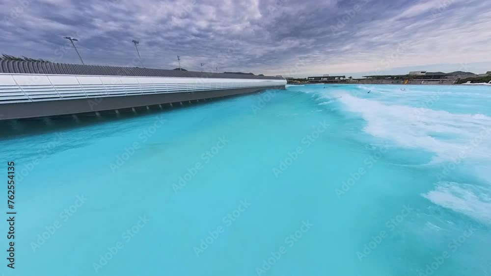 Surfer rides the artificial wave in the surfing pool Surfer rides the artificial wave in the surfing pool