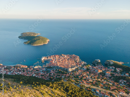 Aerial establishing shot of old town of Dubrovnik with island on Adriatic sea, Dalmatia, Croatia. Medieval city fortress with harbor and yachts. Drone view. Travel destination