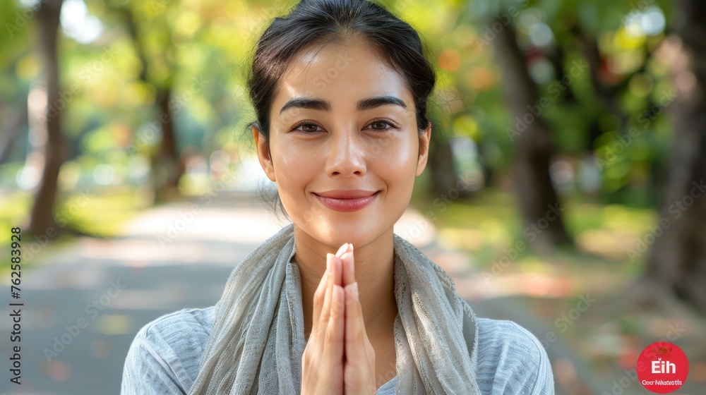 Asian muslim woman smiling, making eid mubarak gesture on blurred background with text space Asian muslim woman smiling, making eid mubarak gesture on blurred background with text space