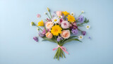 Bouquet of beautiful spring flowers on pastel blue table top view. Greeting card for International Women Day. Flat lay.
