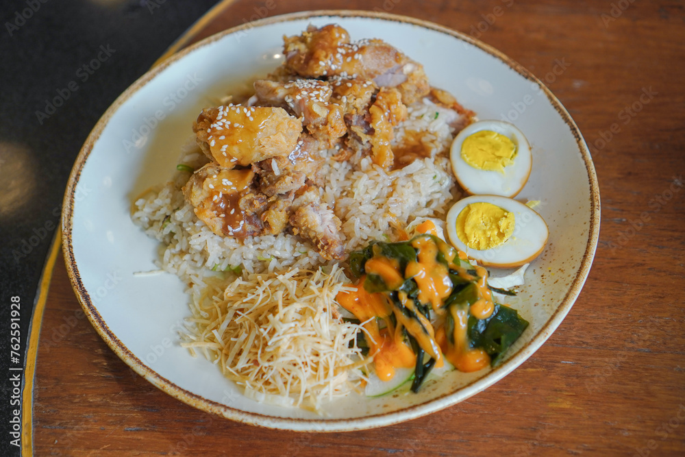 Chicken karage rice and teriyaki sauce sprinkled with sesame seeds on food packaging on a wooden table background Chicken karage rice and teriyaki sauce sprinkled with sesame seeds on food packaging on a wooden table background