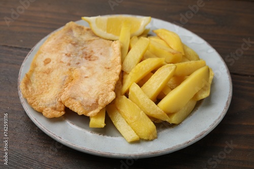 Delicious fish and chips on wooden table, closeup
