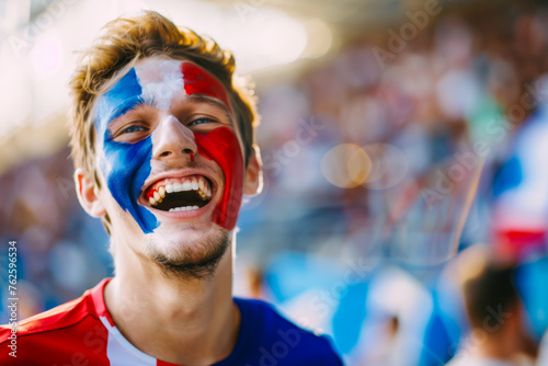 Happy French male supporter with face painted in French flag displaying the country's national colours: blue, white, and red © PixelGallery