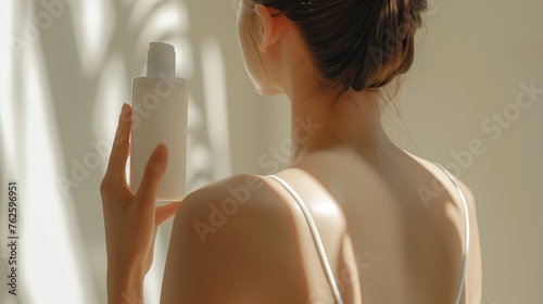Body care theme of woman, holding empty cream and lotion bottles on her shoulder. Focus on the girls' backs, emphasize the skin texture, maintain the softness of women. photo
