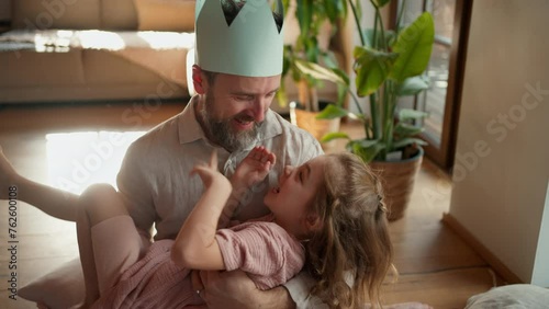 Father with daughter on floor laughing together, having fun, making faces. Girls dad. Unconditional paternal love, Father's Day concept. photo