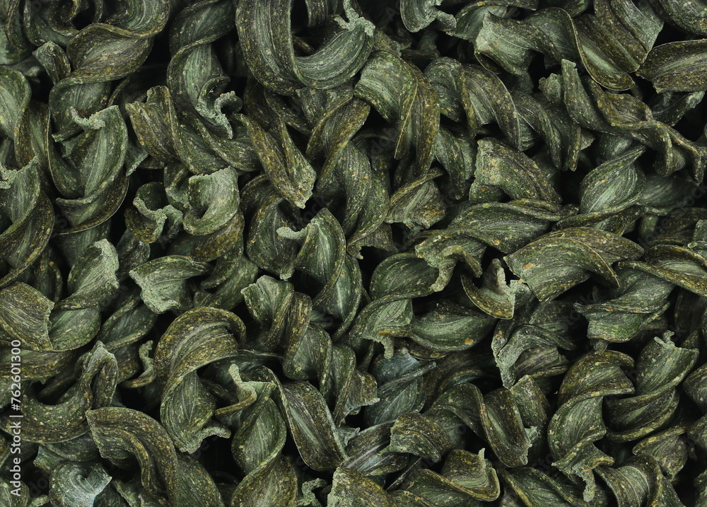 Uncooked fusilli spirulina, organic dry pasta background, top view Uncooked fusilli spirulina, organic dry pasta background, top view