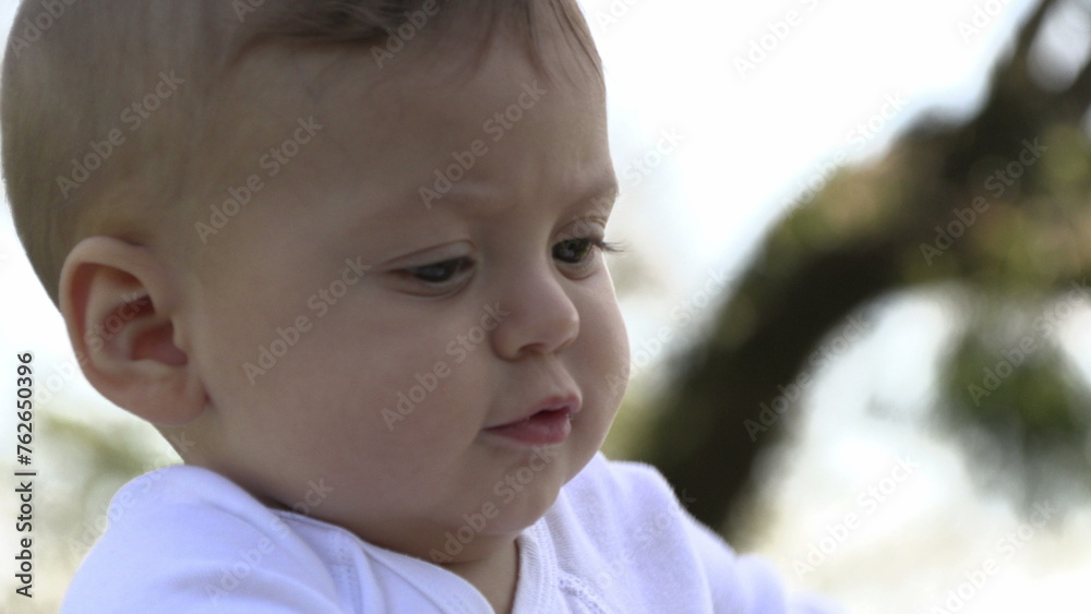Curious baby infant boy learning about the world in outside park Curious baby infant boy learning about the world in outside park
