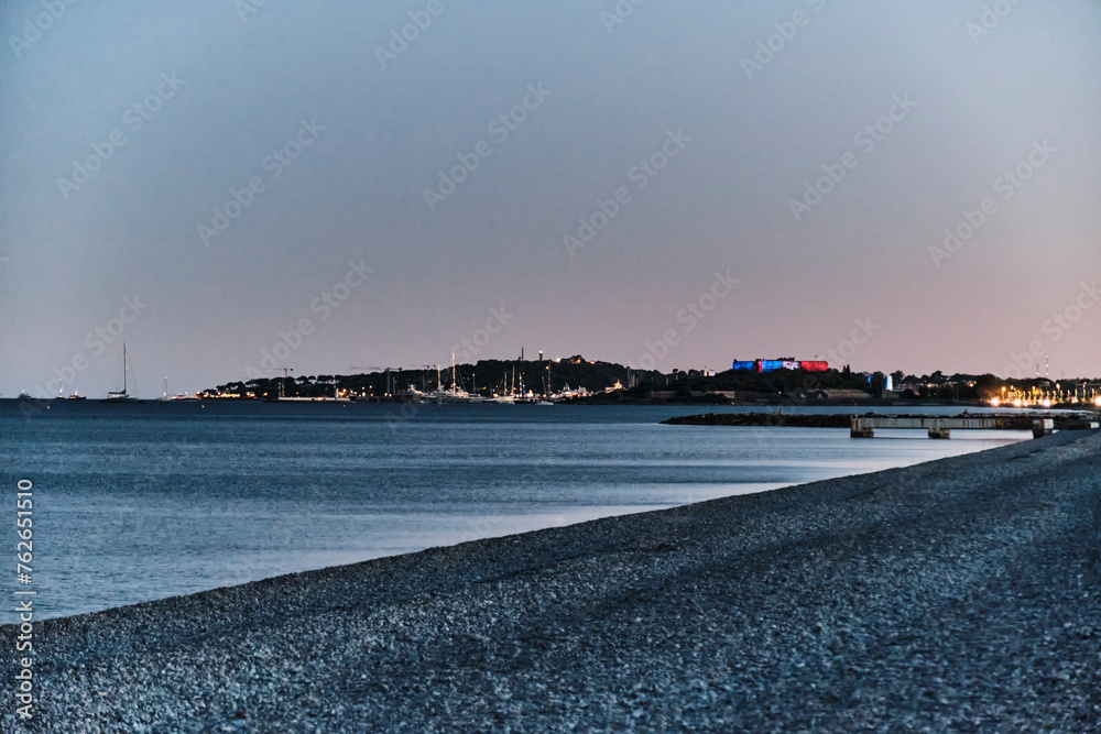 Beautiful coastline of the french riviera at the cote d Azur at Antibes with a pebble beach at sunset.