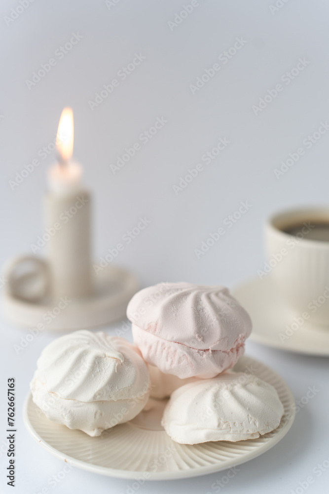 Relaxation time. White delicate marshmallows and coffee on white background
