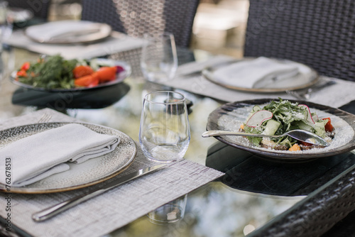 Fototapeta Naklejka Na Ścianę i Meble -  Fresh garden salad on an elegantly set outdoor dining table, perfect for al fresco dining experiences