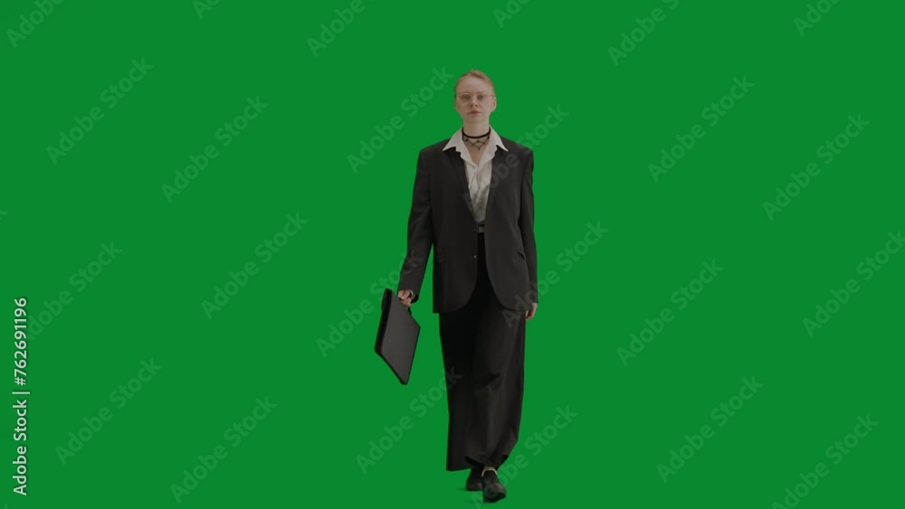 Portrait of female in suit on chroma key green screen. Blonde business woman in formal outfit walking with briefcase. Front view. Portrait of female in suit on chroma key green screen. Blonde business woman in formal outfit walking with briefcase. Front view.