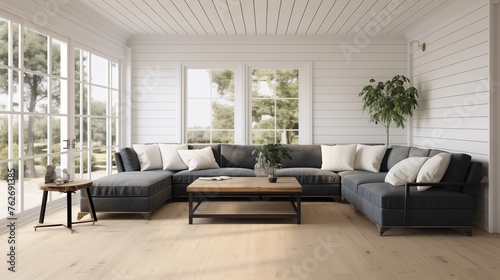 Light oak hardwood floors with a dark charcoal gray sectional and white shiplap walls. © Aeman