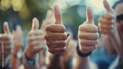 Close-up peoples raising their thumbs up in the air