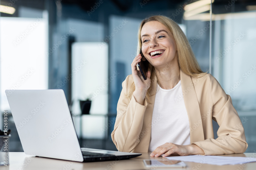 Professional woman talking on a phone at her desk Professional woman talking on a phone at her desk