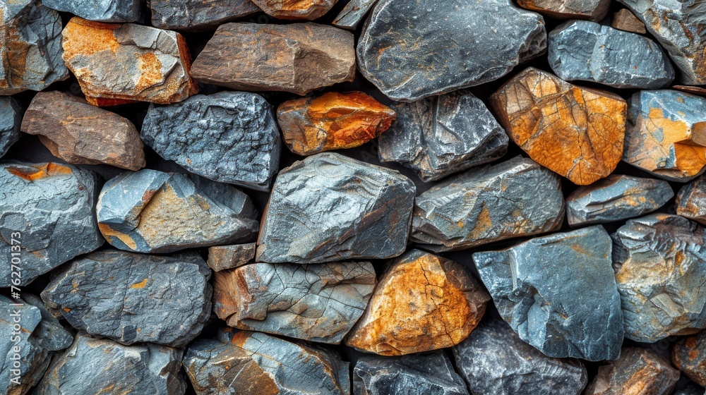 Rocks stacked together on orange, blue, and gray base Rocks stacked together on orange, blue, and gray base