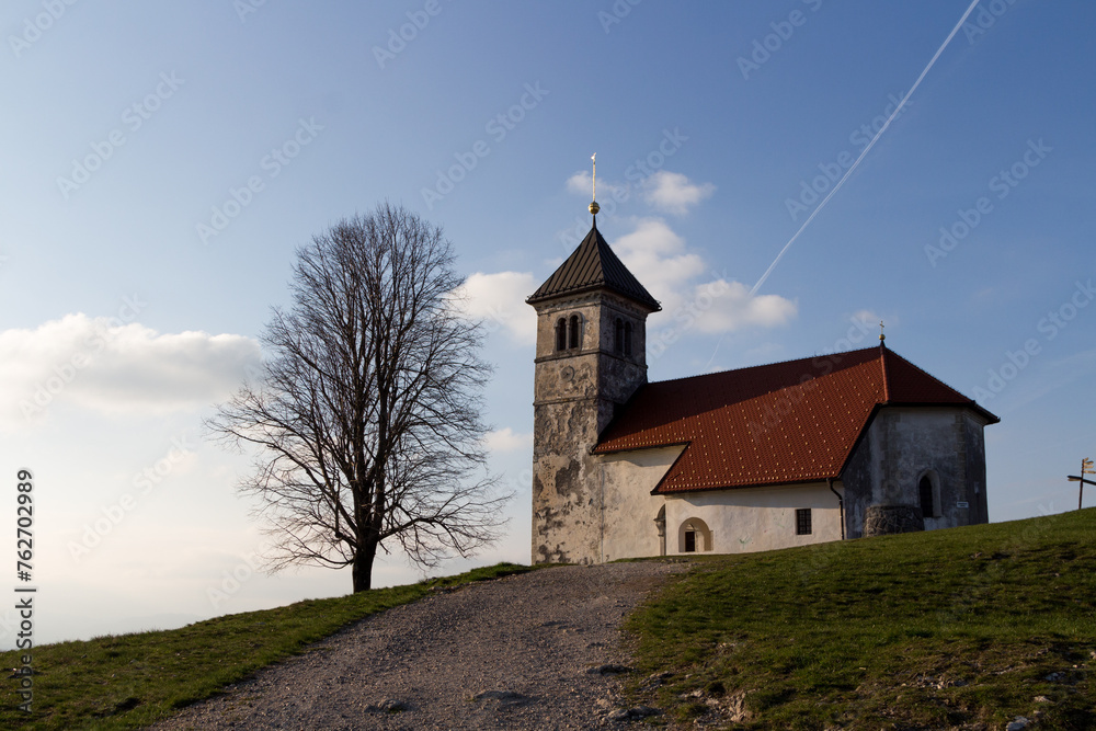 A church of saint Ana on top of the hill and tree near it. A church with a tree and the blue skies.