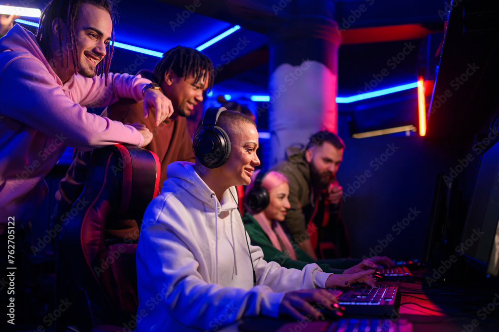 Diverse gamer team playing video games in an internet cafe Diverse gamer team playing video games in an internet cafe