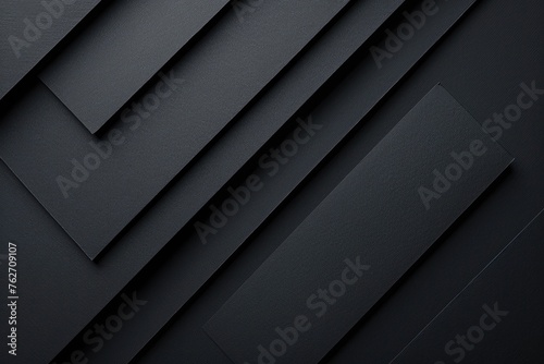 A black and white photo of a stack of black paper. Dark graphite grey abstract textured geometric
