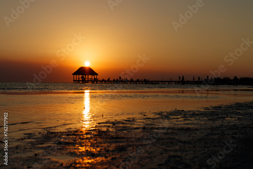 Sunset silhouette view of pier or hut in holbox quintana roo mexico photo