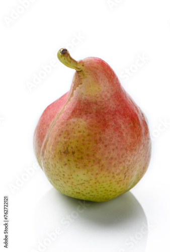 An upright ripe juicy golden and red pear isolated against a flat background.