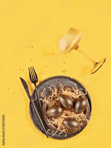 Table place setting and festive easter decor on yellow background. Happy easter greeting or invitation card. Top view, flat lay