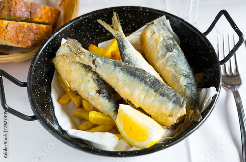 Delicious sardines in Andalusian marinade served with French fries and lemon