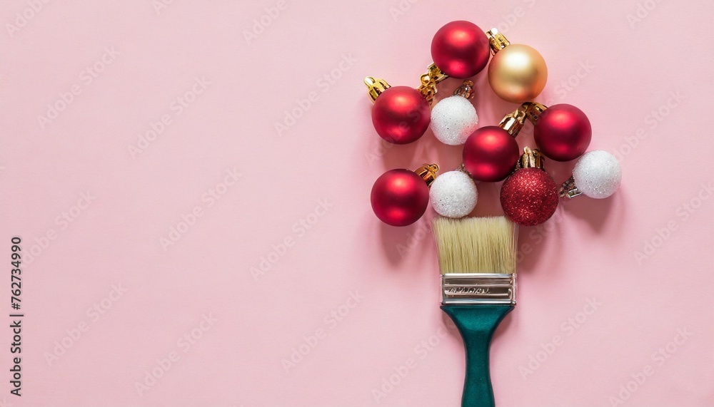 paint brush with christmas ornaments on pastel pink table minimal new year background decoration concept flat lay