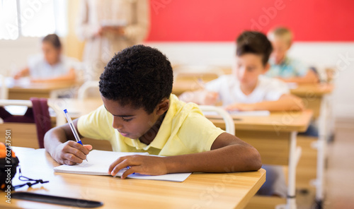 Portrait of an arab boy at school desk in a classroom
