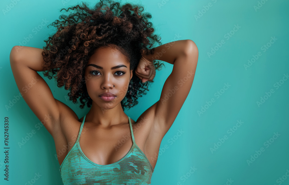 Strong independent girl puts her hands up and shows her muscles on coloured background, feminism female strength