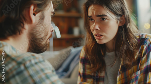 Emotional stressed young couple having argument at home. Portrait of angry irritated man and woman talking and looking at each other with annoyed. Relationship problems, family conflicts