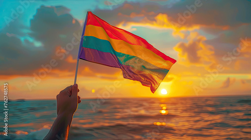LGBTQ  Pride Month Rainbow Flag with sky Background., Rainbow flags showing in hands against clear blue sky, copy space, concept for calling all people to support and respect gender diversity  photo